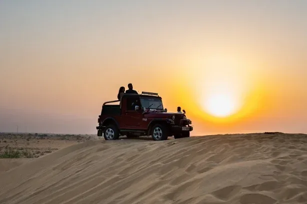 Jeep climbing a sand dune